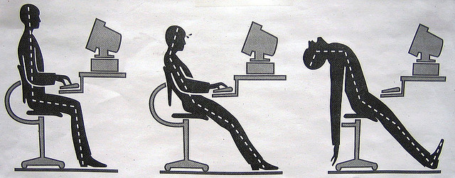 sitting at computer desk with poor posture