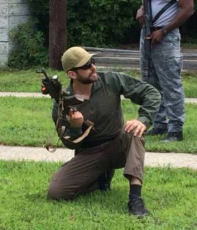 Greg Mihovich crouching with rifle