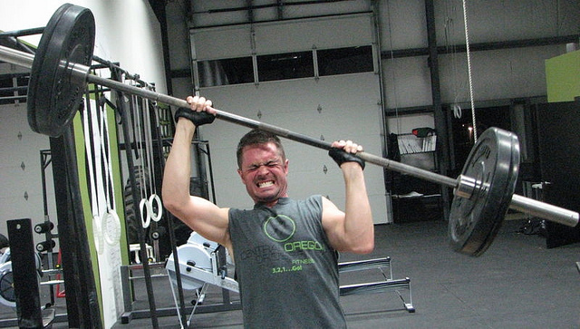 male crossfit athlete dropping barbell on head