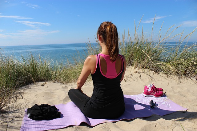 woman on yoga mat at beach